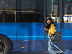 mulher andando ao lado de um ônibus